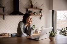 femme utilisant ordinateur dans sa cuisine